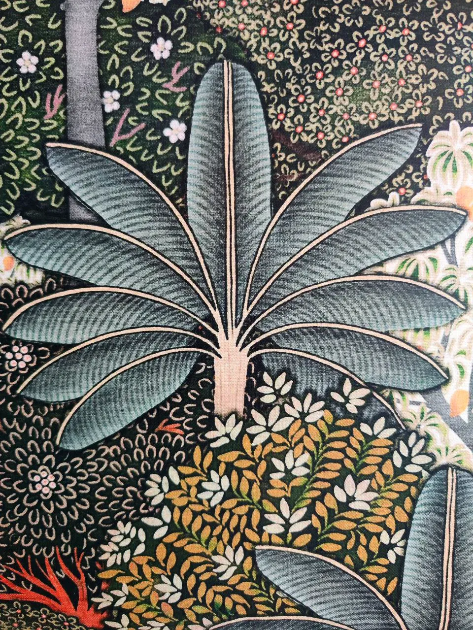 Detalle del papel pintado: hojas de plátano en azul verdoso sobre fondo oscuro.